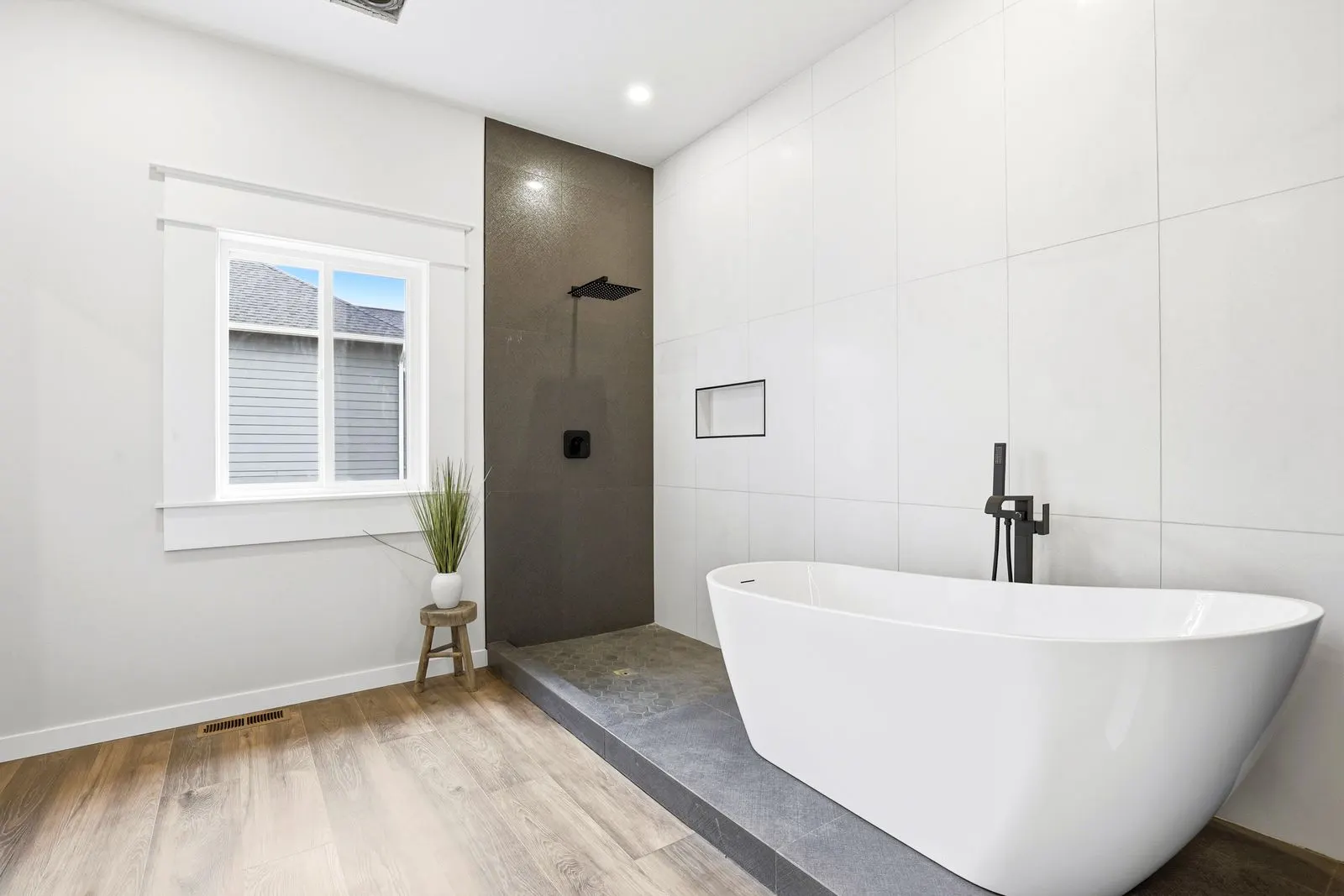 Primary bath with freestanding soaking tub and floor-to-ceiling rain shower