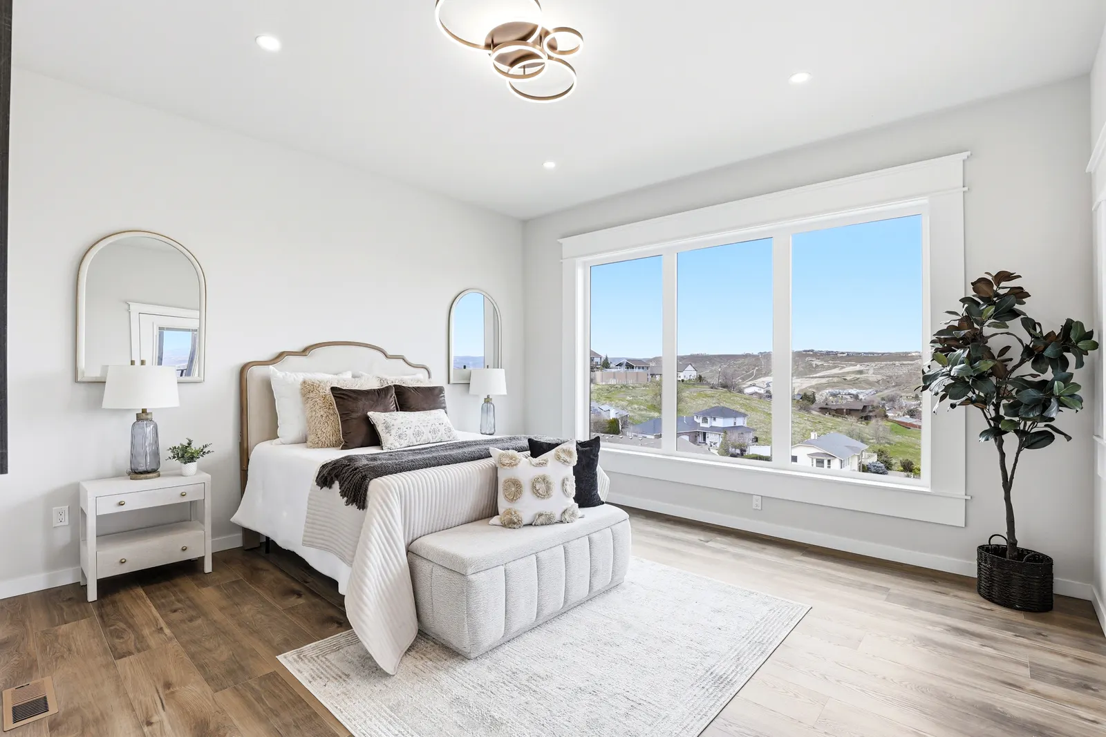 Primary bedroom suite with floor-to-ceiling windows framing valley views