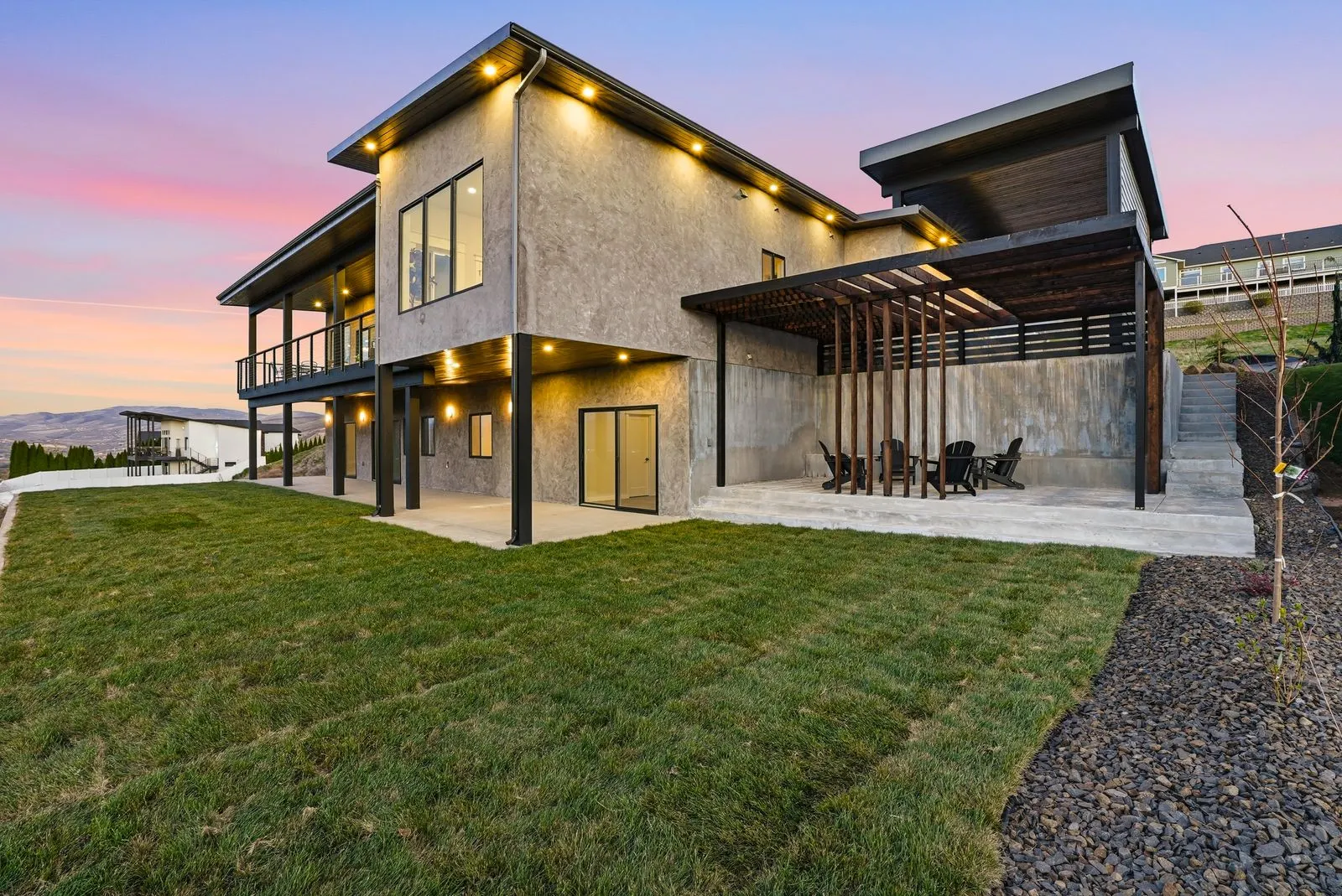 Rear exterior twilight with pergola and Adirondack chairs